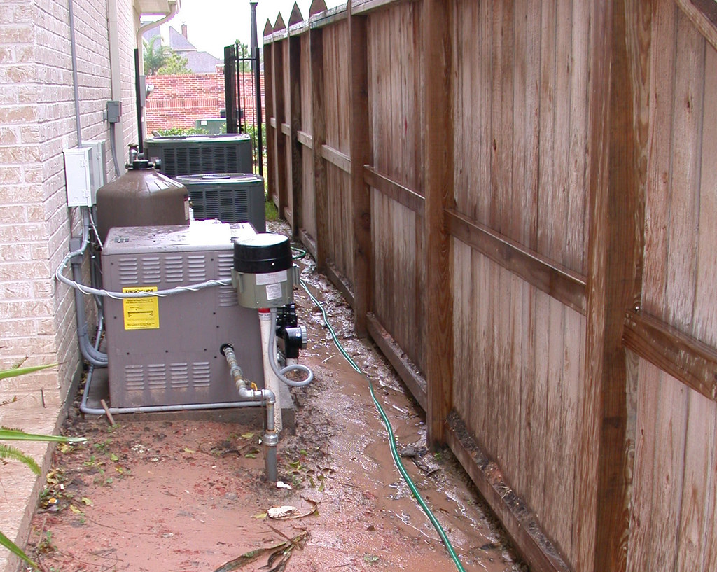 Residential pool equipment area with active water around the pad